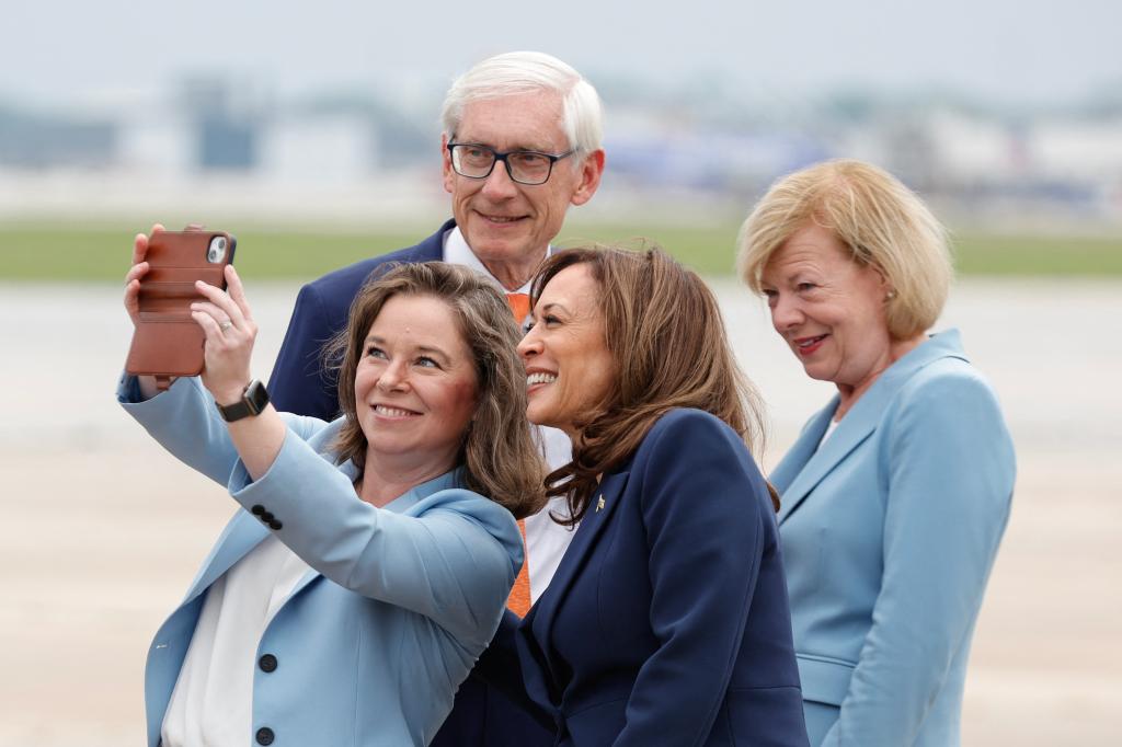 Harris taking a photo with Wisconsin Lieutenant Gov. Sara Rodriguez (left), Wisconsin Gov. Tony Evers and Sen. Tammy Baldwin after arriving in Milwaukee for a campaign event on July 23, 2024.