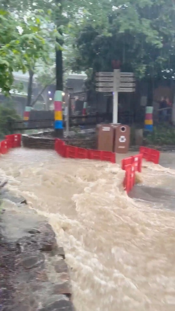 Park-goers wading through flooded walkways and stores during a heavy rain at Dollywood theme park in Pigeon Forge, Tennessee.