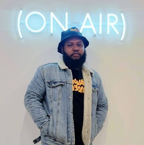 Benjamin Hook (Jammin with Juice Milwaukee radio host) stands in front of an "On Air" sign.