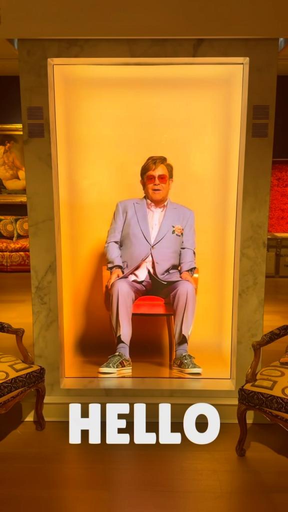 Hologram of Elton John sitting on a chair at Christie's, as viewed on Proto Hologram's Instagram post