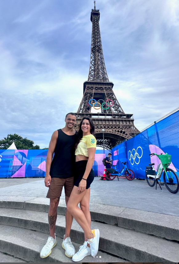 Brazilian swimmers Gabriel Da Silva Santos (left) and Ana Carolina Vieira (right) pose in front of the Eiffel Tower during the 2024 Summer Olympics in Paris.