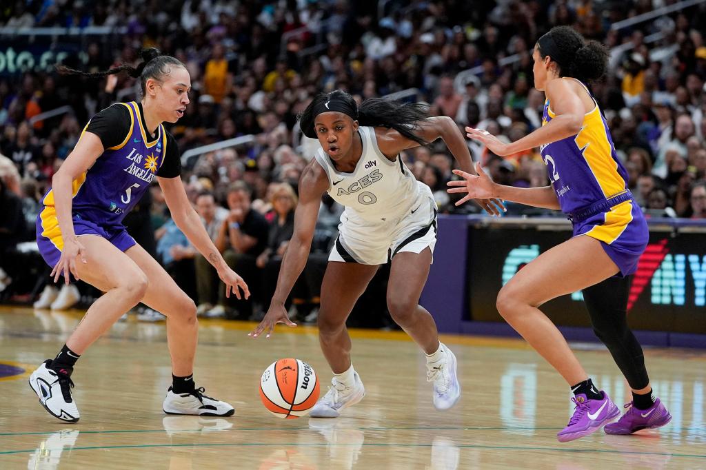 Las Vegas Aces guard Jackie Young (0) drives against Los Angeles Sparks forward Dearica Hamby, left, and guard Rae Burrell during the second half of a WNBA basketball game Friday, July 5, 2024, in Los Angeles.