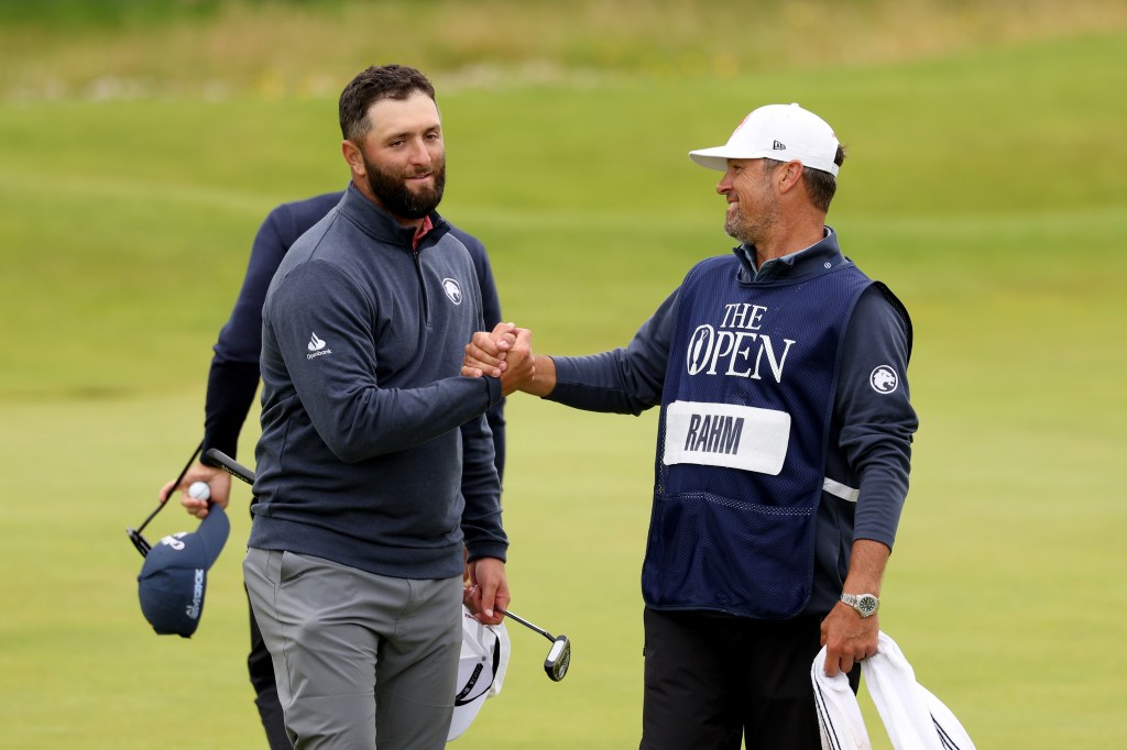 Jon Rahm of Spain interacts with his caddie Adam Hayes on the 18th green during day four of The 152nd Open championship at Royal Troon on July 21, 2024 in Troon, Scotland.