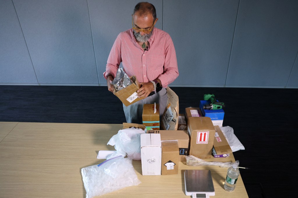 Journalist Maurice Tamman examining fentanyl precursors recently unboxed at Reuters' office in New York City