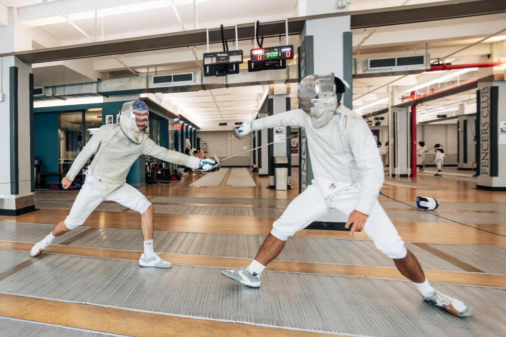 Mitchell Saron and teammate Eli Dershwitz in fencing gear at The Fencer's Club in Manhattan, July 10, 2024