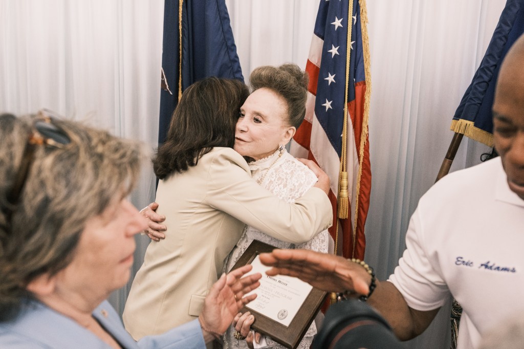 Adams embracing Hochul after she officially became a high school graduate.