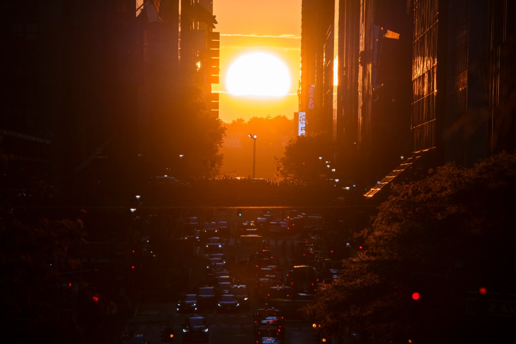 People stopping to watch the sunset along 42nd Street in Times Square, New York City, the day before Manhattanhenge