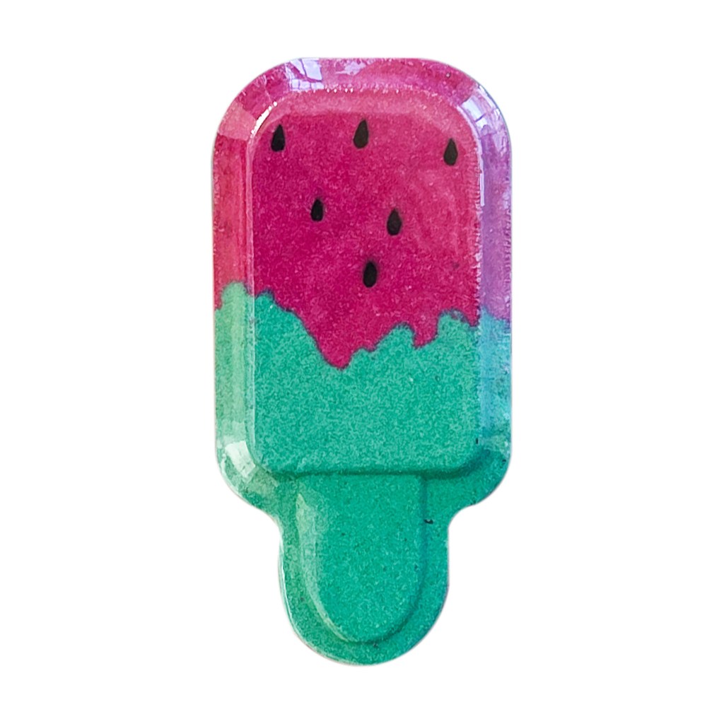 A close-up image of Holler And Glow Lick Me Plz watermelon scented bath bomb shaped like a popsicle, available at Target.com