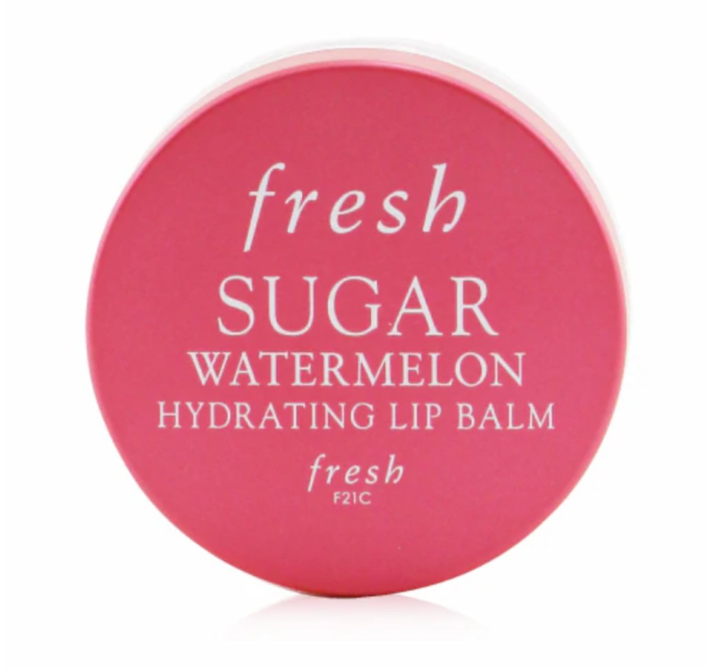 A round pink container of Sugar Watermelon Hydrating Lip Balm with white text