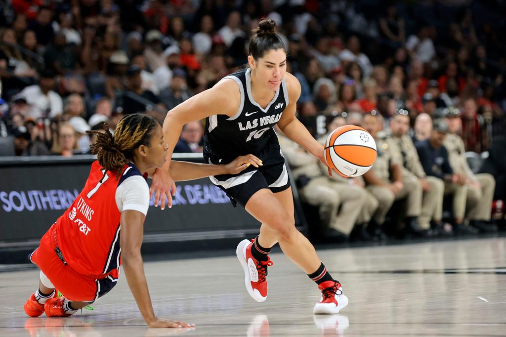 Las Vegas Aces guard Kelsey Plum (10) takes the ball past Washington Mystics guard Ariel Atkins (7) during the first half of an WNBA basketball game Thursday, July 4, 2024, in Las Vegas. 