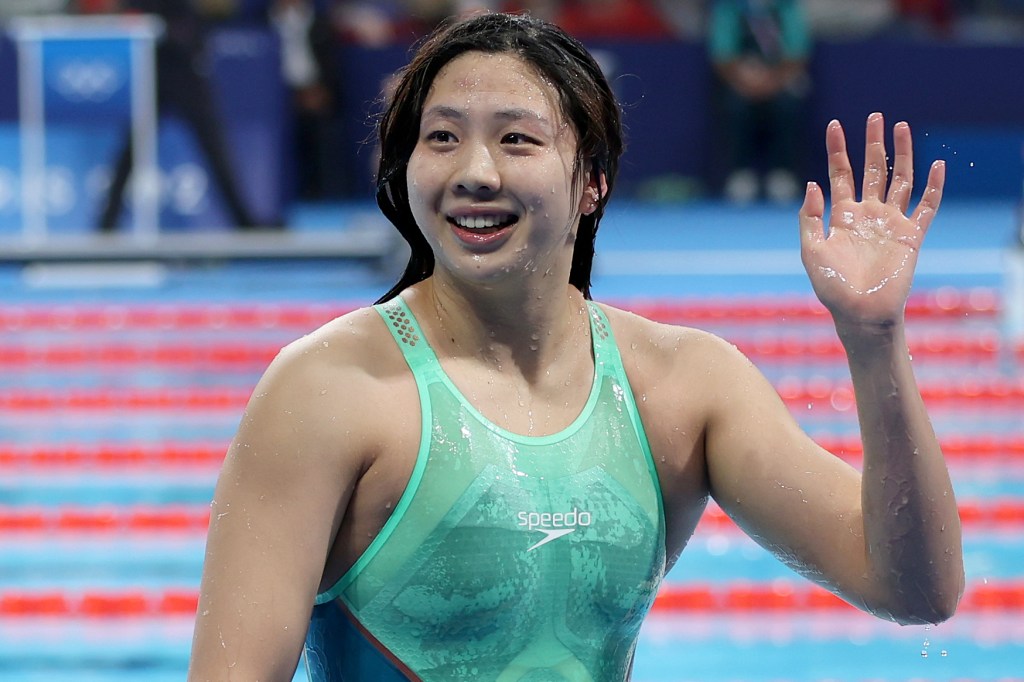 Tang Qianting smiles and waves at the crowd in her viral swimsuit.