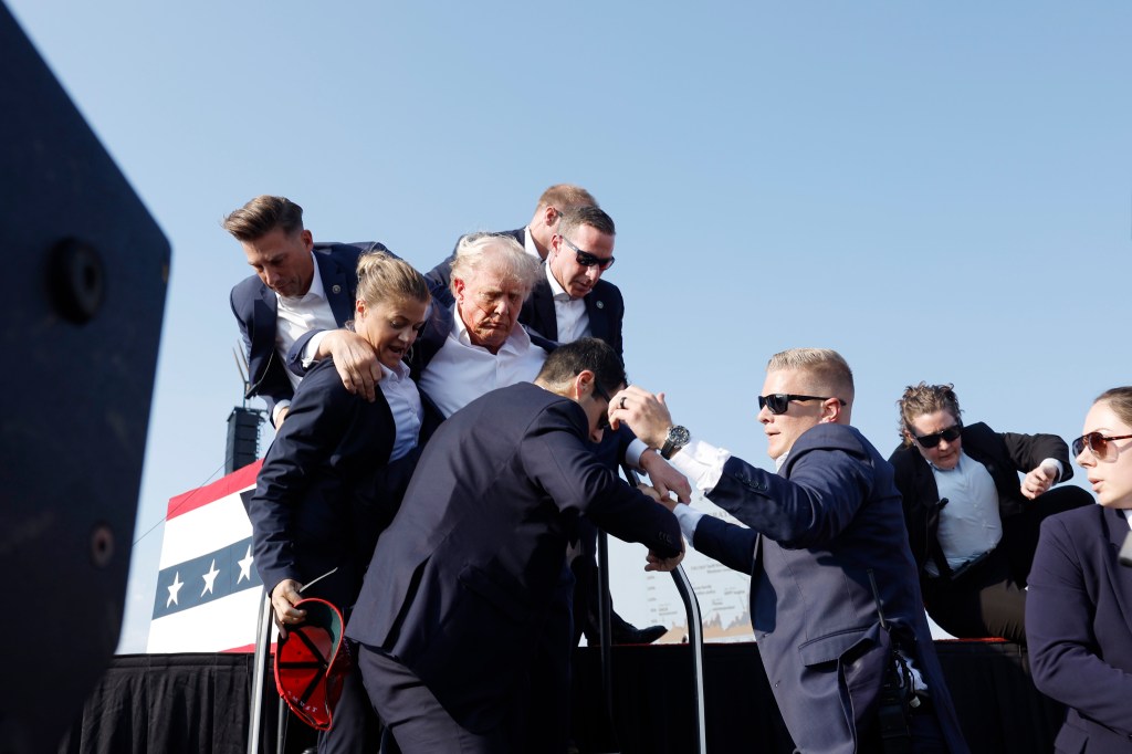 Trump getting rushed off the stage by Secret Service agents.