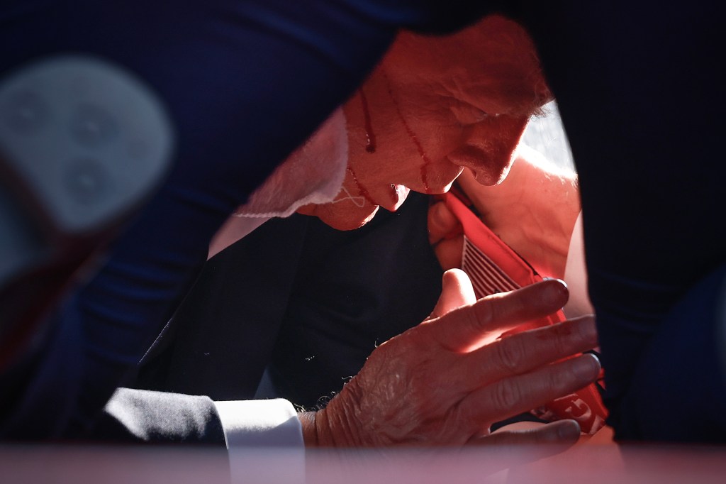 Trump on the ground with blood all over his face.