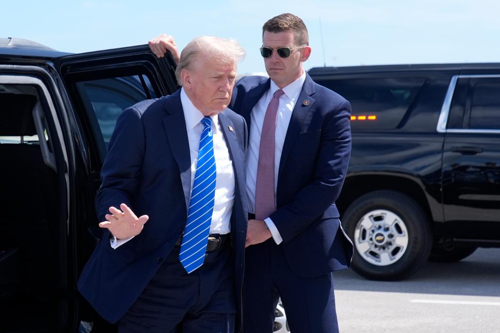 Trump waves as he arrives to board his plane at Palm Beach International Airport before heading to Nashville. 