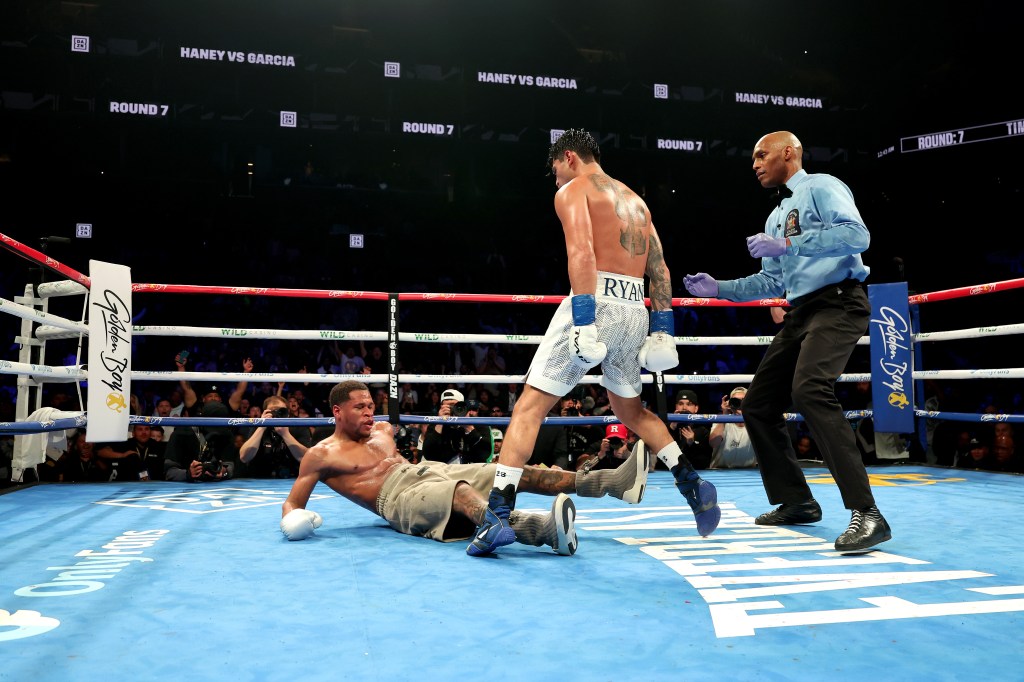 Ryan Garcia knocks down Devin Haney during their bout on April 20, 2024. 