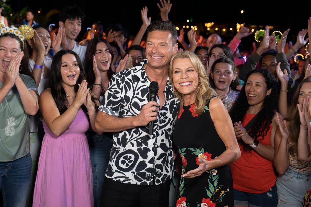 Ryan Seacrest and Vanna White on American Idol stage, interacting with crowd in the background