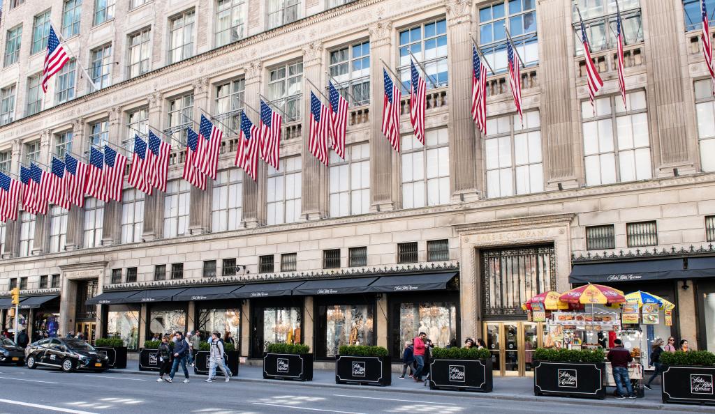 Saks Fifth Avenue store building on Fifth Avenue in New York City with multiple flags on the side