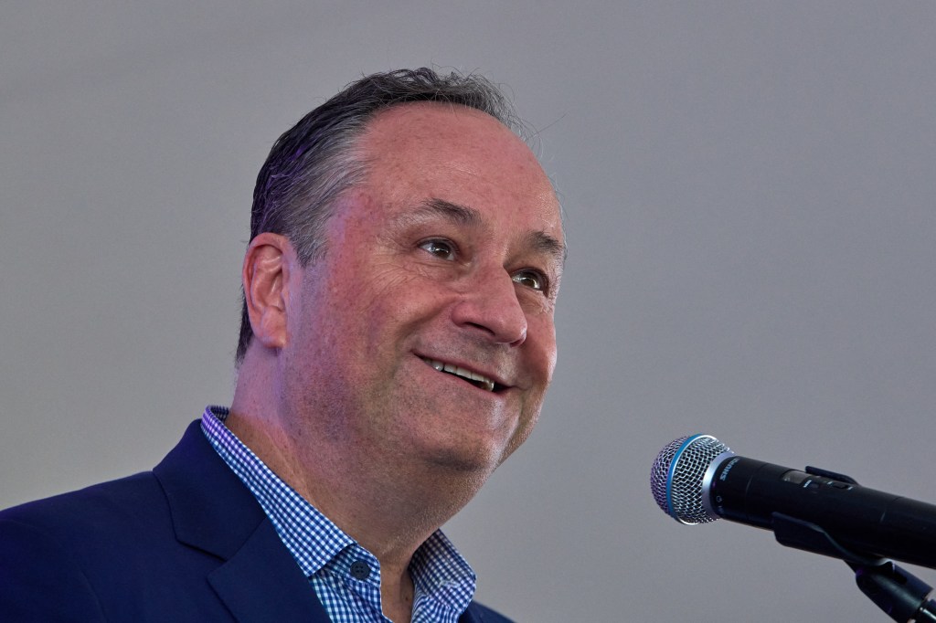 Second Gentleman Doug Emhoff speaking at the Hmong Wausau Festival in Wisconsin, wearing a blue suit