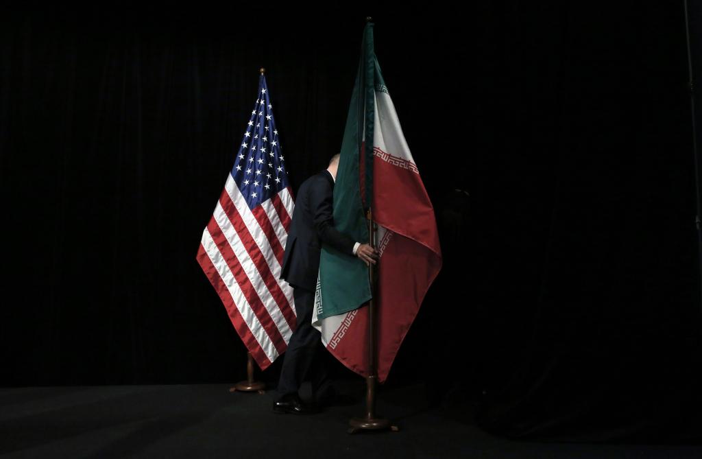 A staffer removes the Iranian flag from a stage during a 2015 international conference aimed at preventing Tehran from gaining nuclear capability.