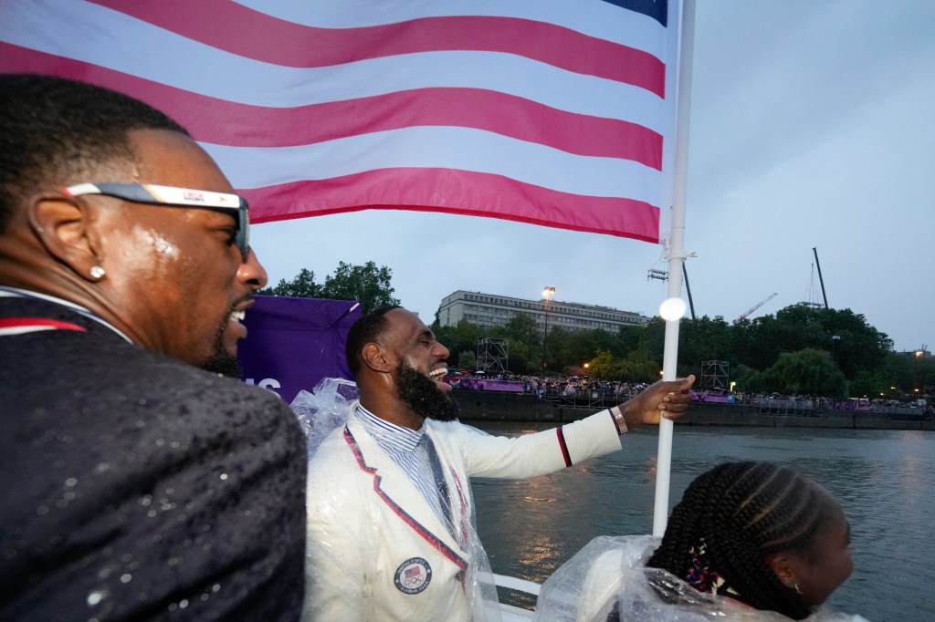 LeBron James carries the U.S. flag during the opening ceremonies of the 2024 Paris Olympics.