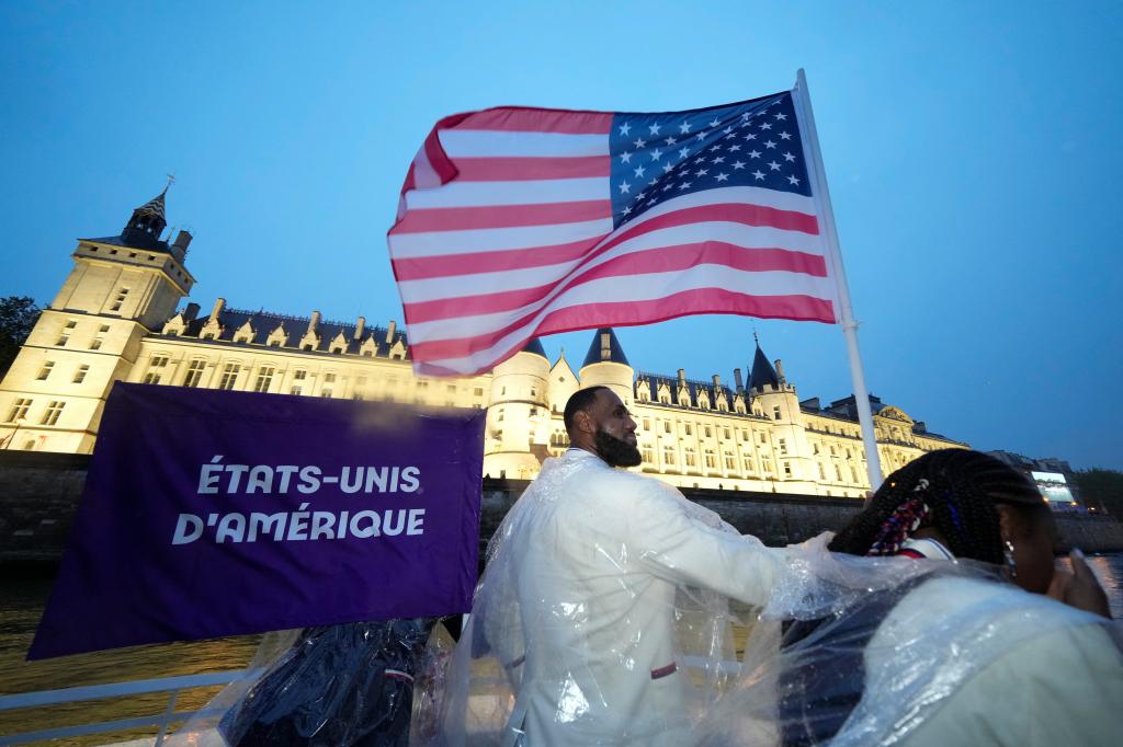 LeBron James carries the U.S. flag during the opening ceremonies of the 2024 Paris Olympics. 