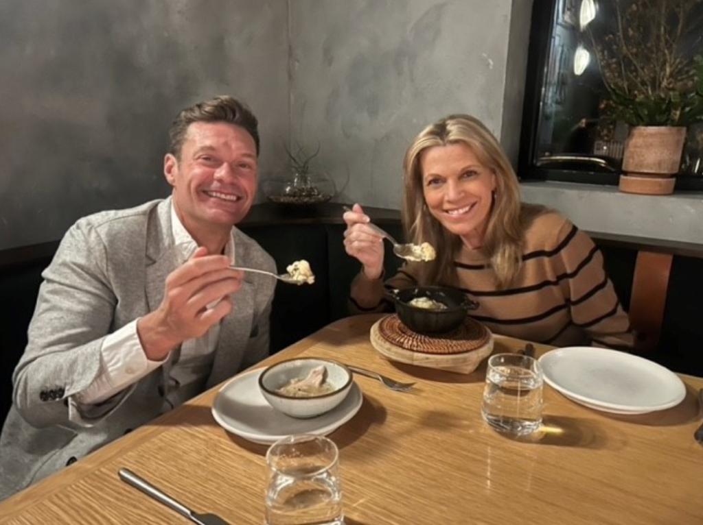 Ryan Seacrest and Vanna White dining together at a table