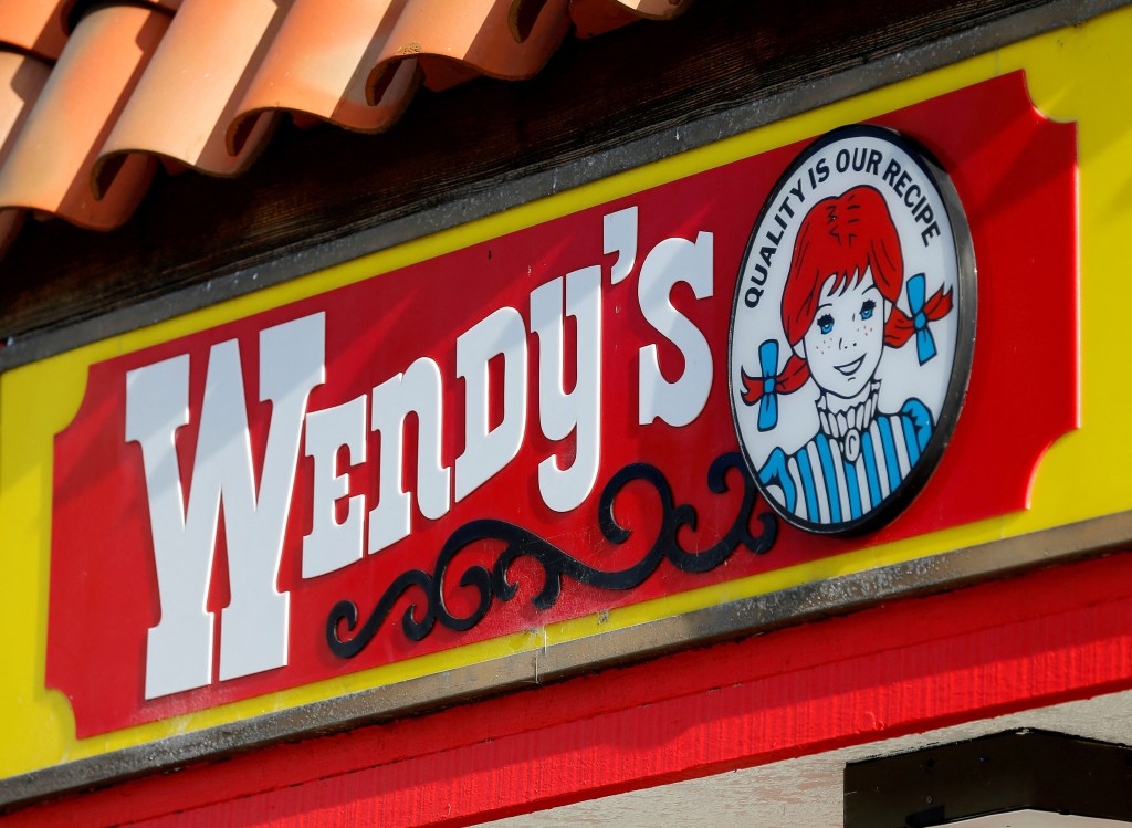 Wendy's restaurant sign and logo displayed on a building in Encinitas, California, reflecting on the potential impact on hiring in smaller chains.