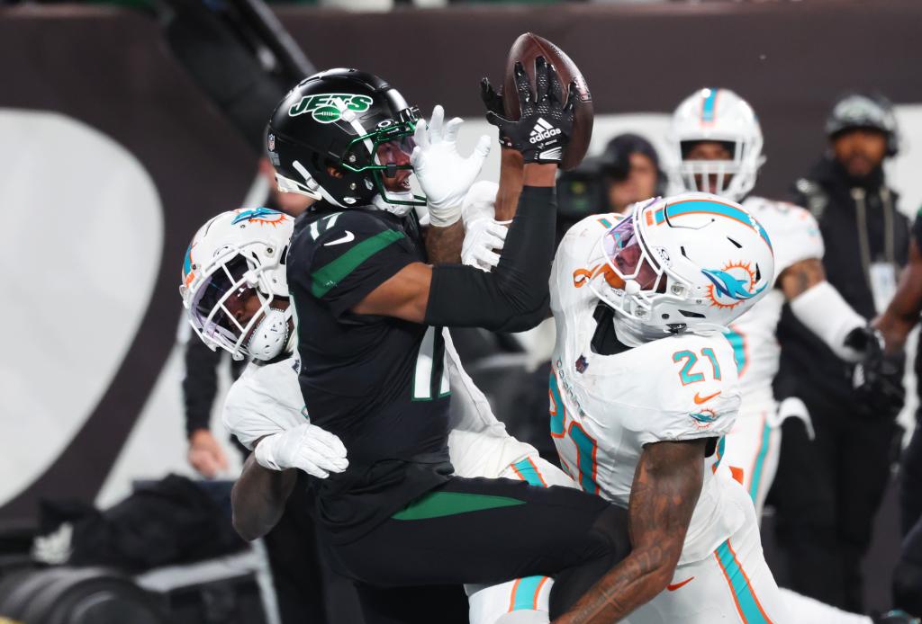 A Jets player is tackled by players from the Miami Dolphins