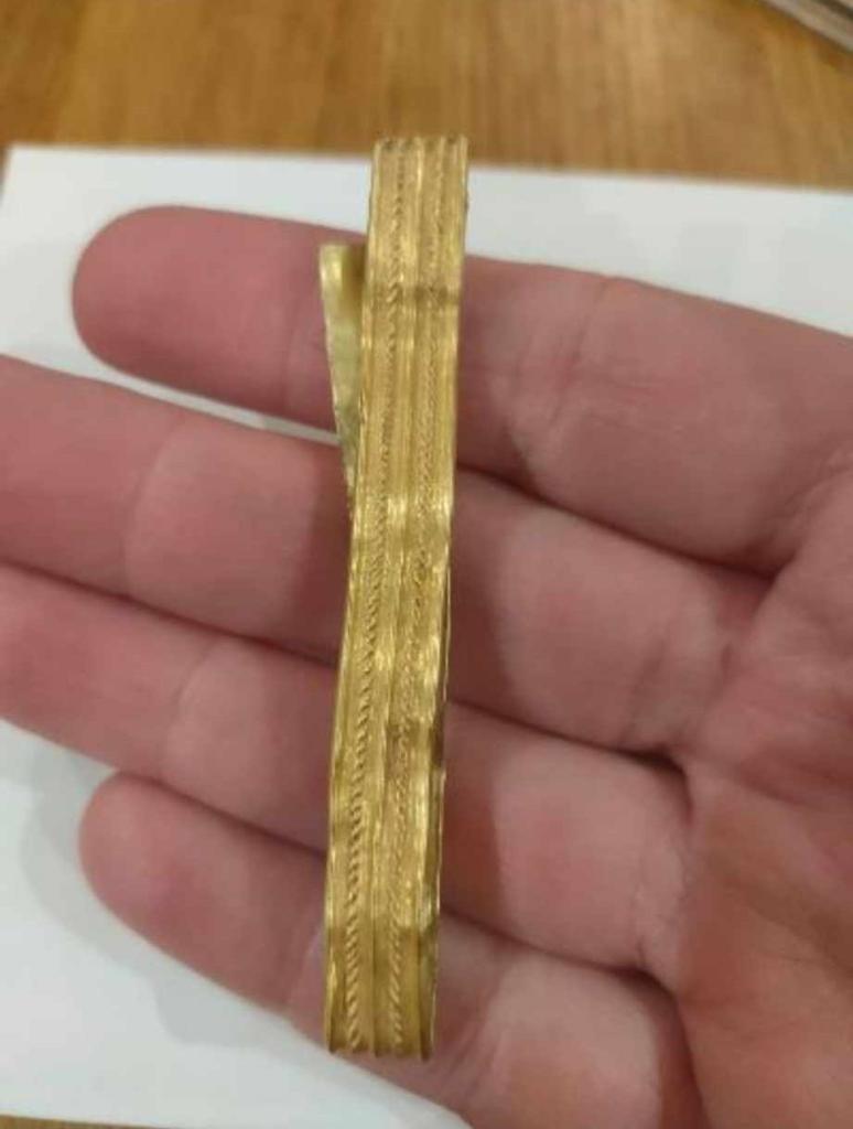 12-year-old boy holding a rare 2,000-year-old gold Roman bracelet found in a field