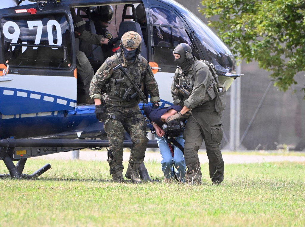 The alleged perpetrator of the knife attack in Solingen is escorted from a helicopter in Karlsruhe, Germany, Sunday, Aug. 25, 2024. 