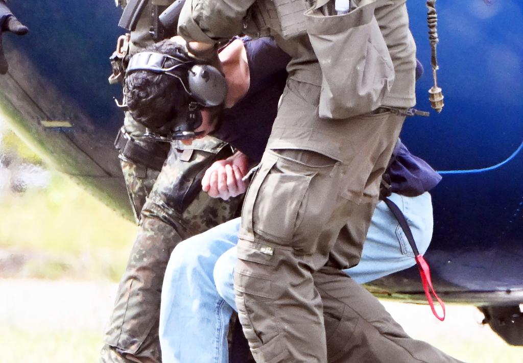 The alleged perpetrator of the knife attack in Solingen is escorted from a helicopter in Karlsruhe, Germany, Sunday, Aug. 25, 2024. 