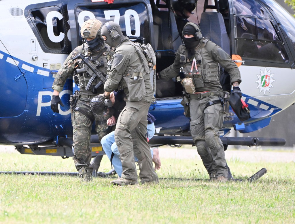 The alleged perpetrator of the knife attack in Solingen is escorted from a helicopter in Karlsruhe, Germany, Sunday, Aug. 25, 2024. 