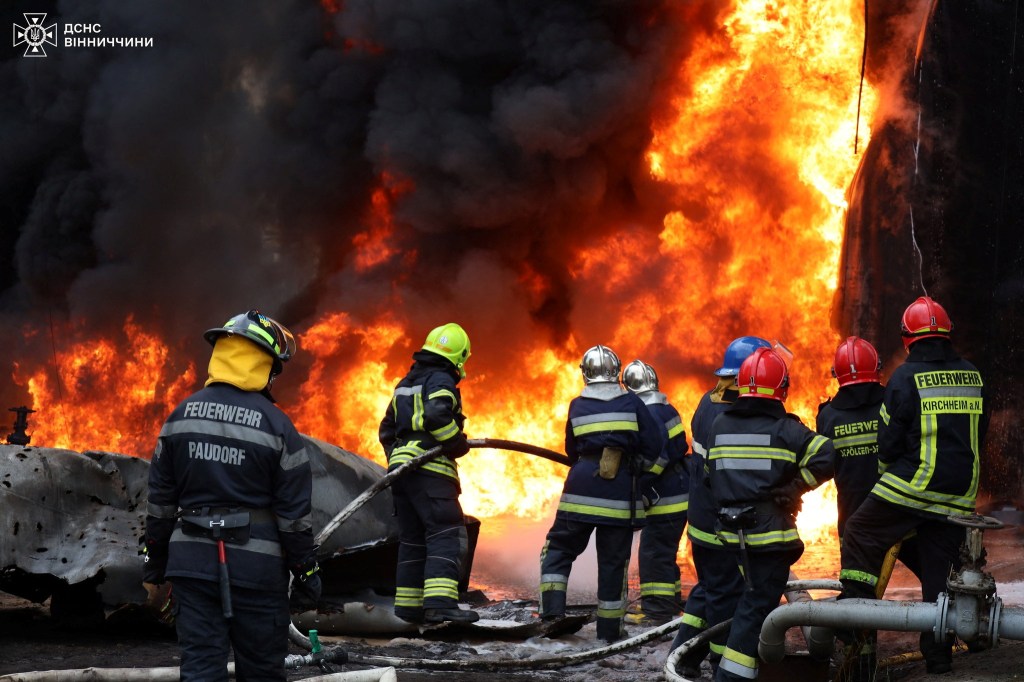 Firefighters working at the site where a critical infrastructure facility was damaged during a drone strike, on August 3.