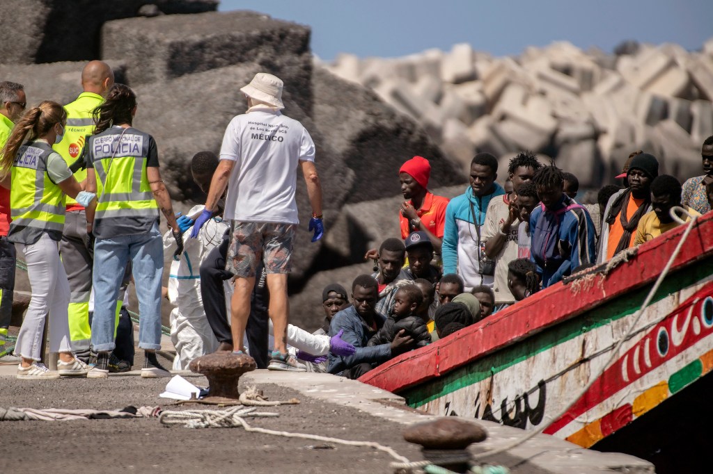 Police forces and emergency services assisting 175 migrants arriving on a boat at Restinga port on the Canary island of El Hierro