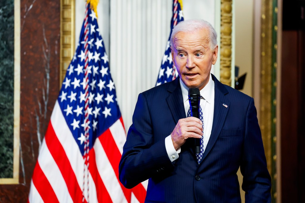 President Joe Biden speaking at the White House Creator Economy Conference in the Indian Treaty Room, holding a microphone