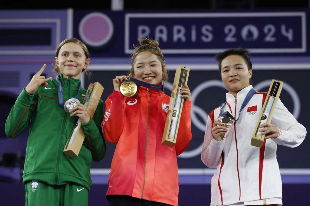 Lithuania's Dominika Banevic known as Nicka (silver), Japan's Ami Yuasa known as Ami (gold) and China's Liu Qingyi known as 671 (bronze) pose during the podium ceremony for the Women's Breaking dance Round robin of the Paris 2024 Olympic Games at La Concorde in Paris, on August 9, 2024. 