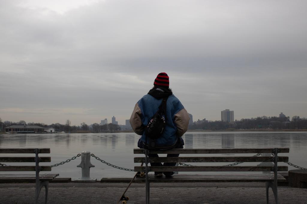 A person sitting on a bench looking at the water, image titled 'Tudor' by Fiona Chen, a digital inkjet print housed at Studio Museum in Harlem.