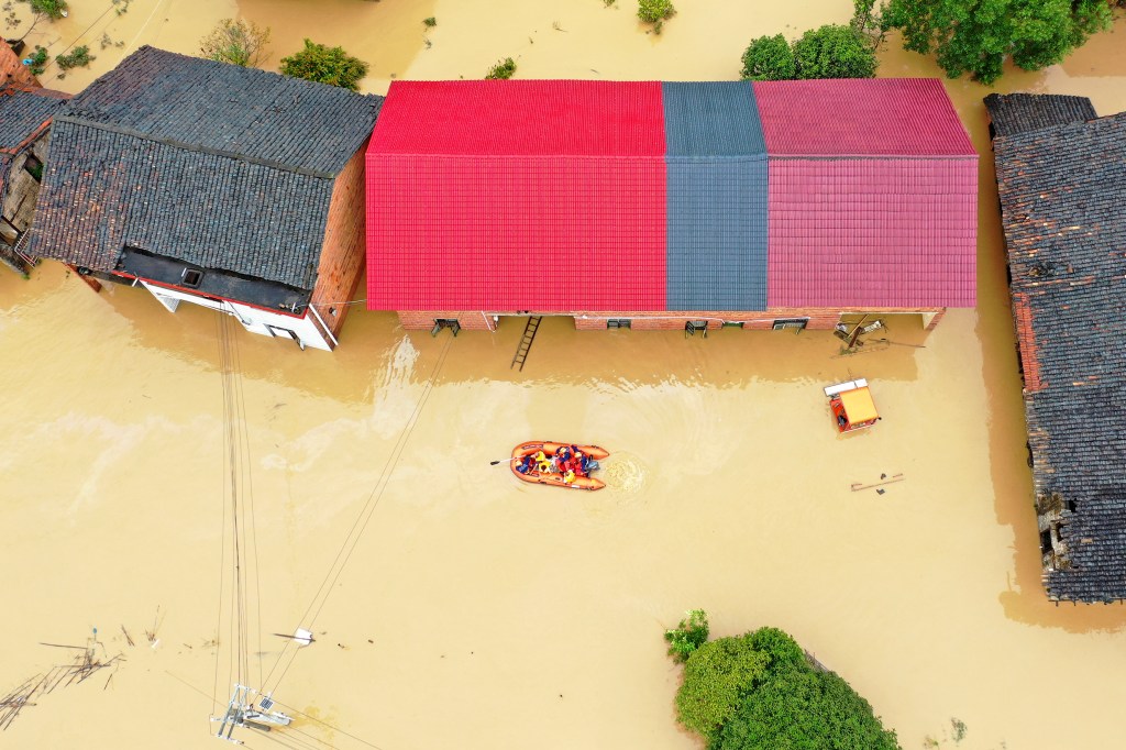 Rescuers use a dinghy boat to evacuate villagers trapped by floodwaters in Jingtang village, Zixing city, in southern China's Hunan province, on July 28, 2024. 