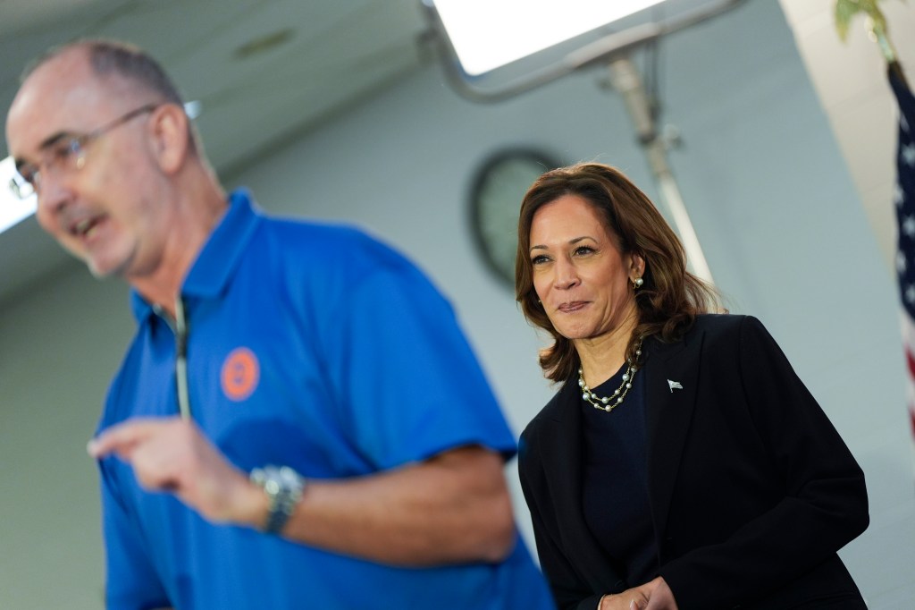 Vice President Kamala Harris listening to UAW President Shawn Fain at a campaign rally in Wayne, Michigan, 2024
