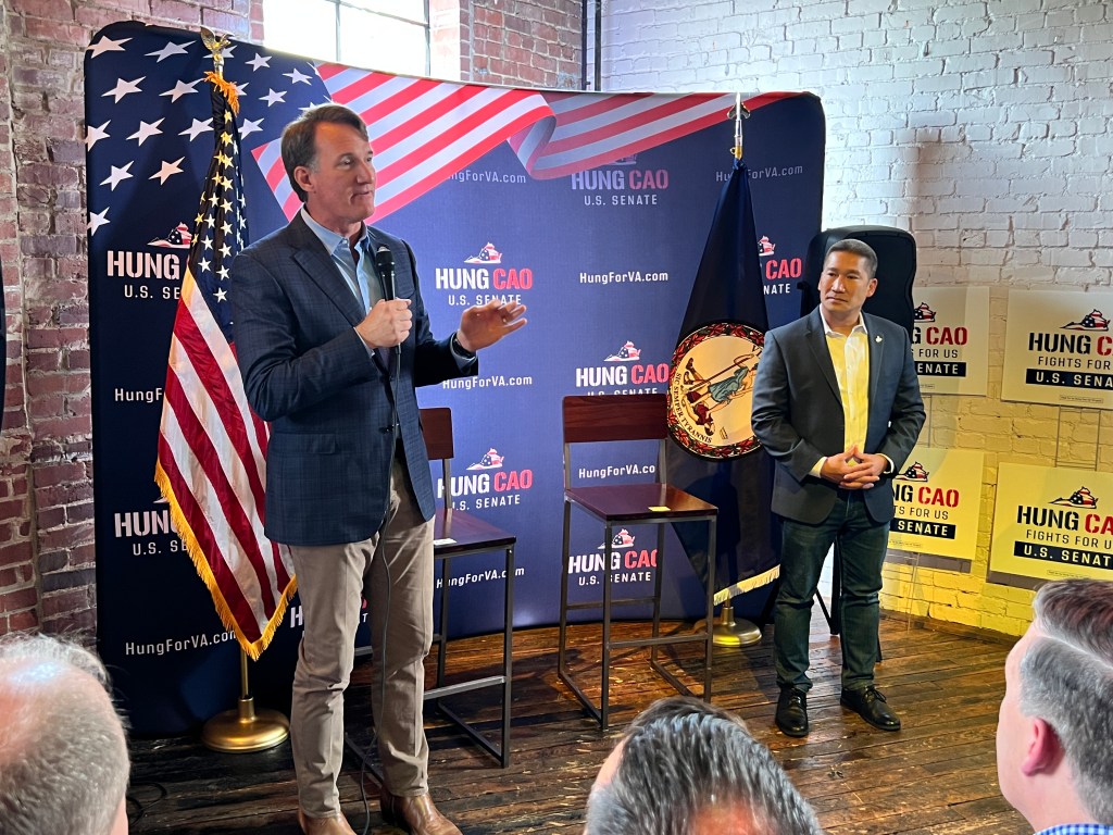 Governor Glenn Youngkin and VA GOP Sen. nominee Hung Cao at a campaign event, with one man standing in front of a microphone