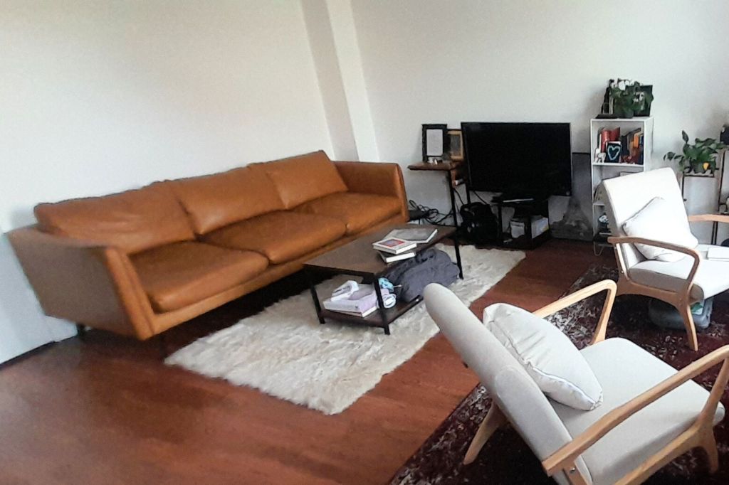 A brown leather couch in a living room.