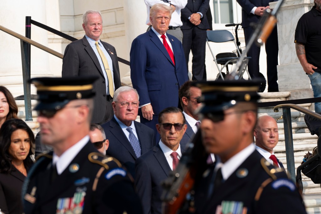 Bob Quackenbush, top left, deputy chief of staff for Arlington National Cemetery, and Republican presidential nominee former President Donald Trump watch the changing of the guard at the Tomb of the Unknown Solider