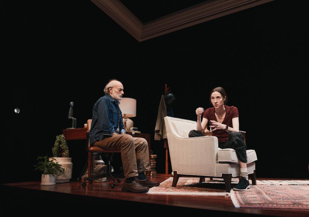 Peter Friedman and Sydney Lemmon sitting on couches