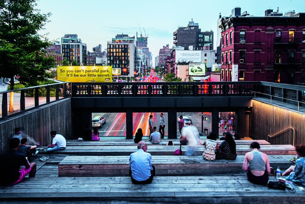 The High Line with people sitting on wooden platforms.