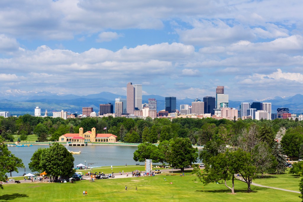 Downtown Denver city skyline from City Park with the Rocky Mountains in the distance, Colorado, USA