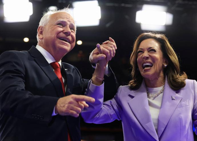 TIm Walz holds hands with Kamala Harris.