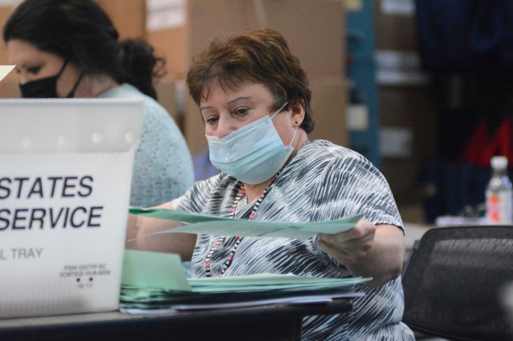 Election bureau staff, Deb McDonald, opening provisional ballots in Schuylkill County Election Bureau, Pottsville, Pa, with both Democrat and Republican poll watchers present.