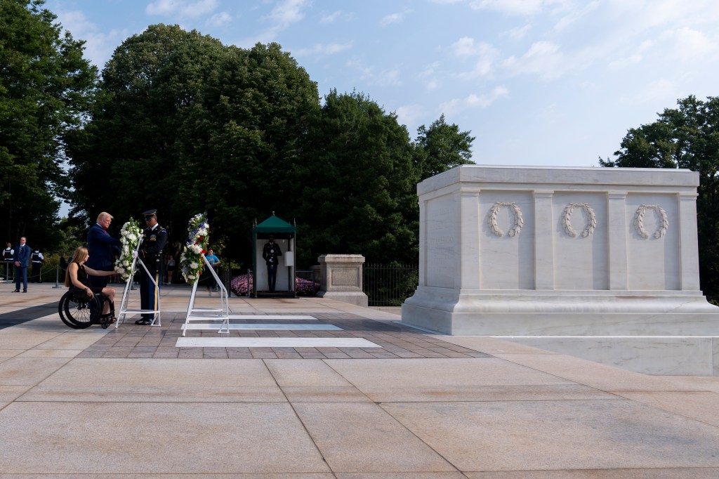 Former Marine Corps Cpl. Kelsee Lainhart, left, and Republican presidential nominee former President Donald Trump place a wreath at the Tomb of the Unknown Solider.