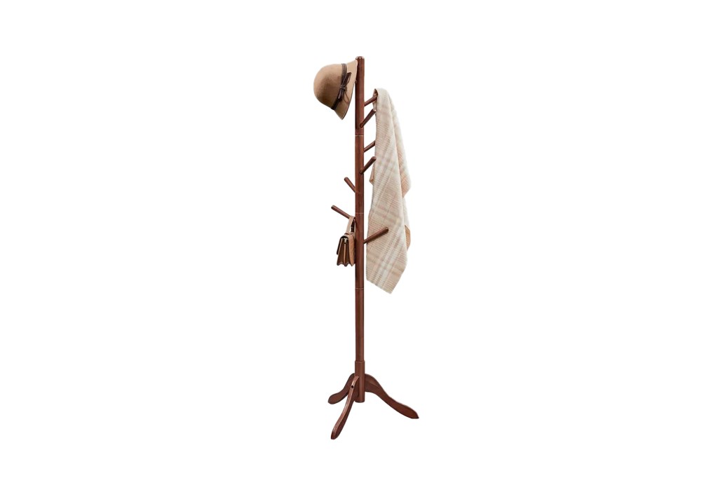 A coat rack with a hat and a blanket hanging on it