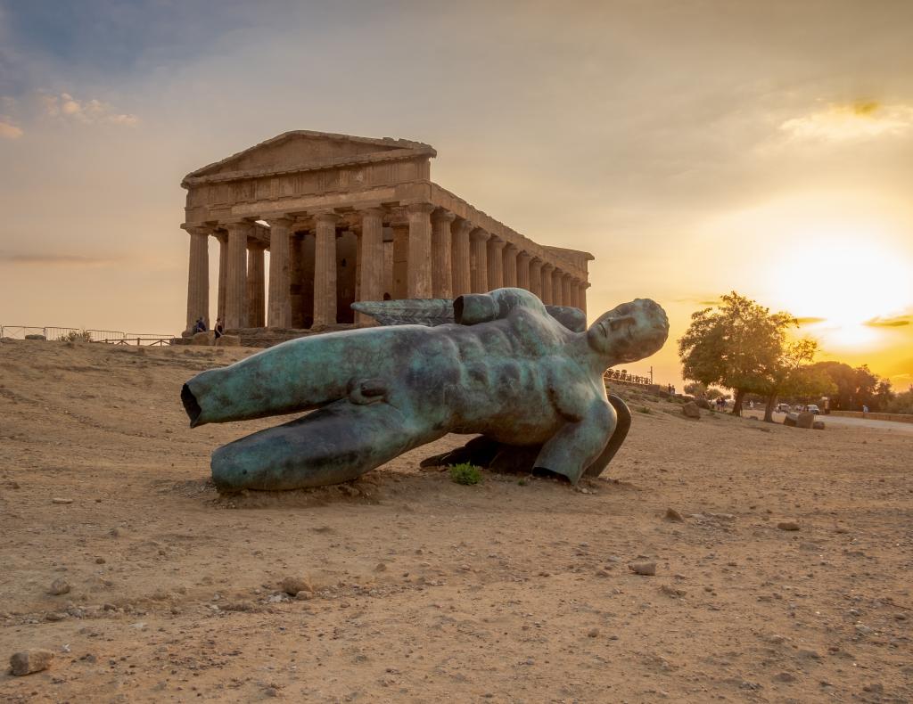 Icarus, modern bronze sculpture, falled in front of the Temple of Concordia, Valley of Temples, Agrigento province, Sicily, Italy